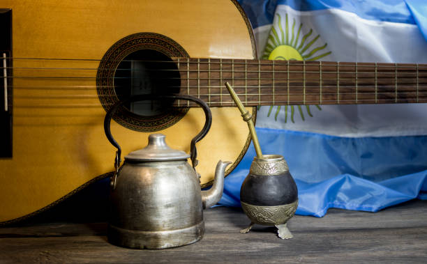 Imagen de una guitarra, pava y mate. De fondo la bandera Argentina.
