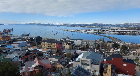 Imagen del centro de Tierra del Fuego. Se ven varios edificios el mar y montañas.